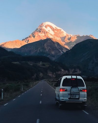 银suv附近道路上冰雪覆盖山白天
